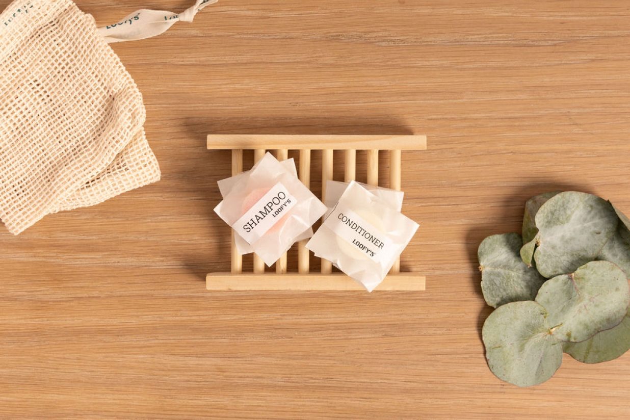 Loofys-hotel-basic-bovenaanzicht van hele lijn op houten ondergrond, met zeepzakje en eucalyptus-liggend