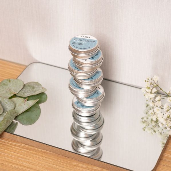 Loofys-hotel-blikjes-stapel op spiegel, met eucalyptus en bloemen-liggend